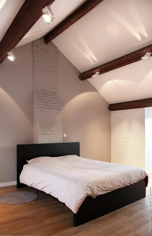 Chambre moderne aux tons naturels avec plafond poutres apparentes et parquet