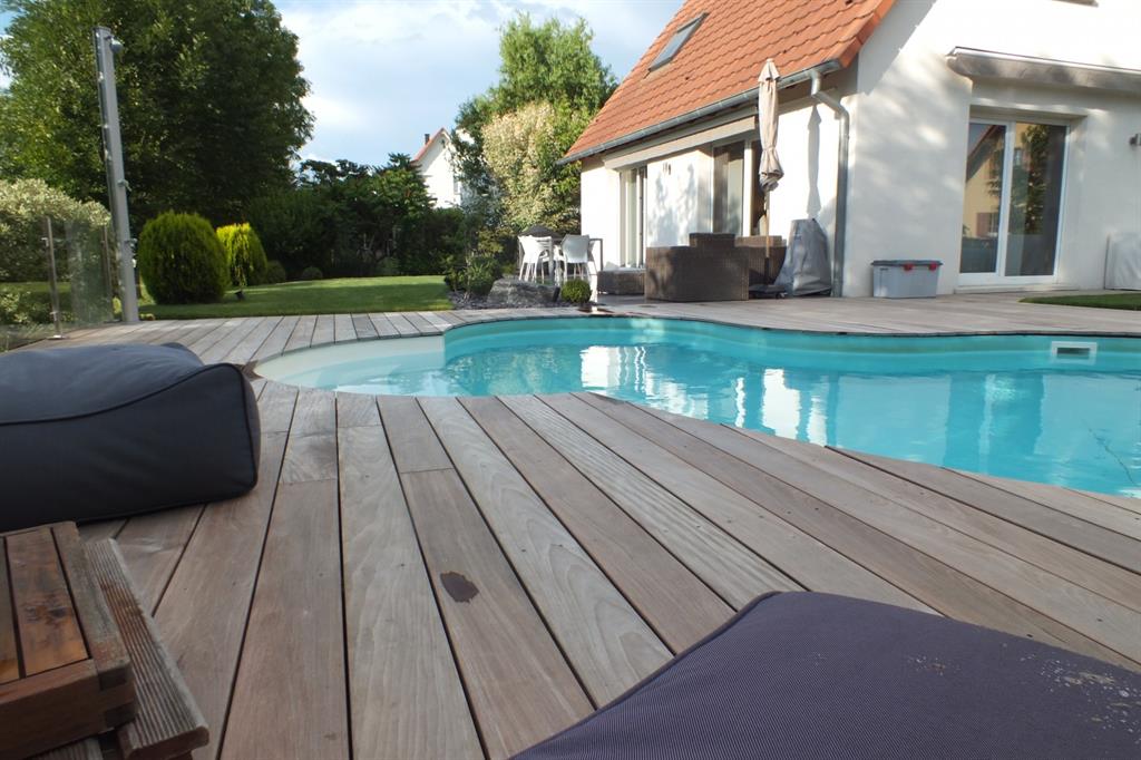 Piscine traditionnelle forme libre avec terrasse en bois
