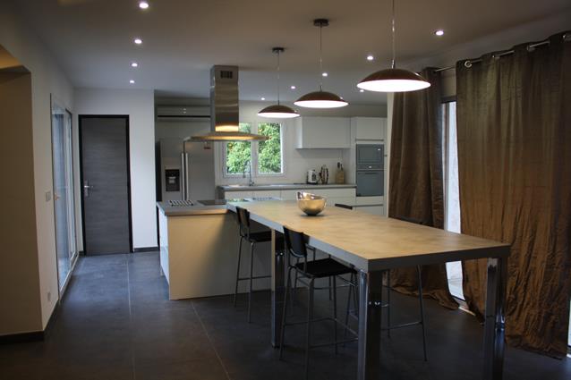 Spacieuse cuisine avec une grande table prolongeant le plan de travail