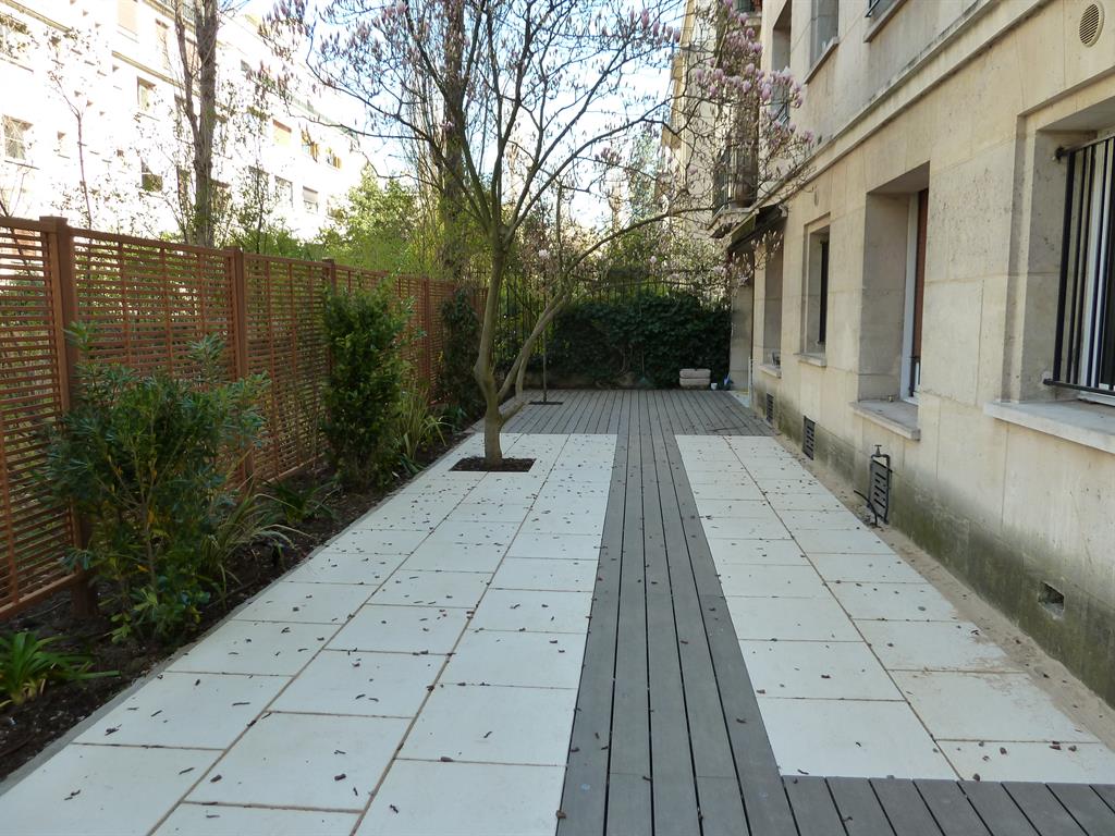 Terrasse en bois composite gris encastrées dans un dallage clair
