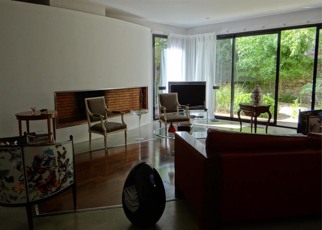 Salon moderne délimité par une zone en parquet foncé 