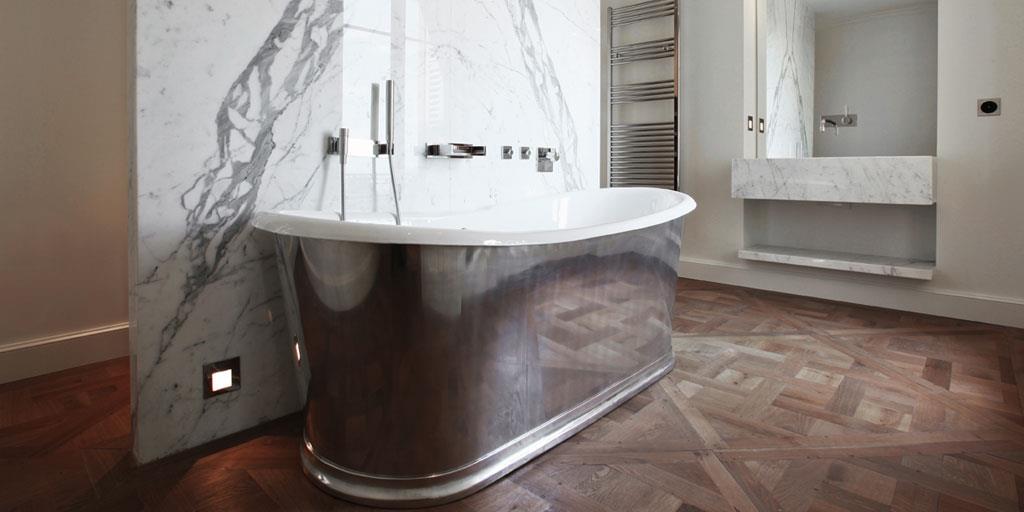 Salle de bain avec une baignoire design recouverte de métal brossé