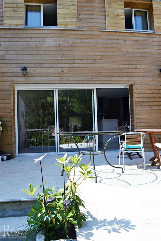 Façade au bardage en bois percée d'une grande baie vitrée