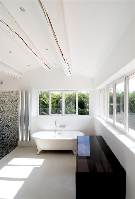 La salle de bain intègre une baignoire ancienne dans un environnement moderne