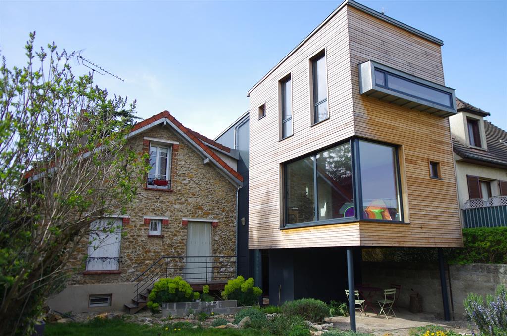 Maison contemporaine en bois et baies vitrées. Terrasse ombragée sous le plancher 