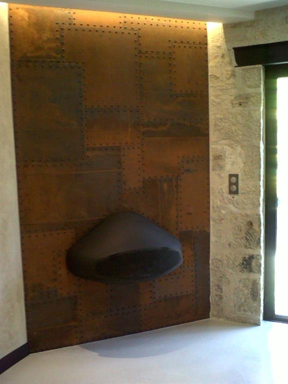 Le mur de la cheminée est constitué de plaques d’acier rivetées