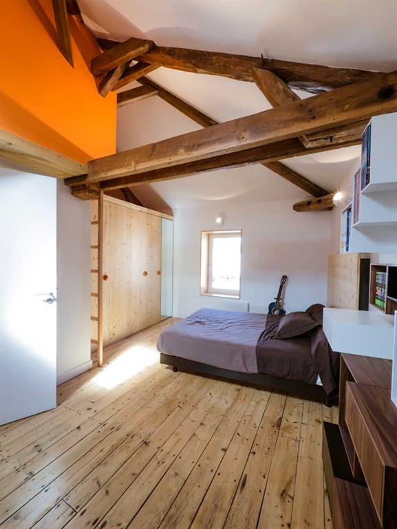 Chambre aménagée en soupente avec poutres apparentes