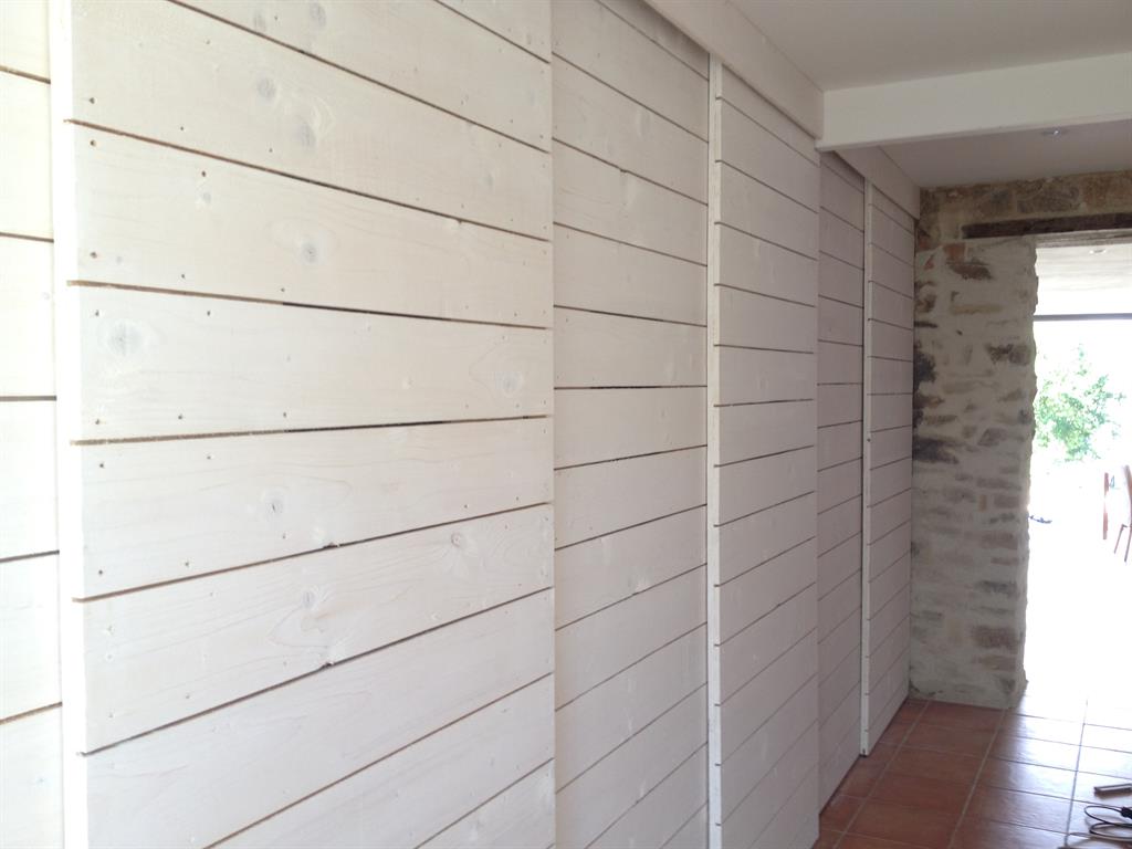 Dressing aux portes coulissantes en lattes de bois blanc 