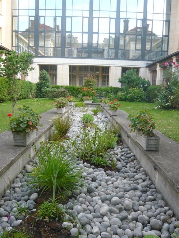Aménagement du jardin d'agrément du lycée Montaigne à Paris avec bassin de galets