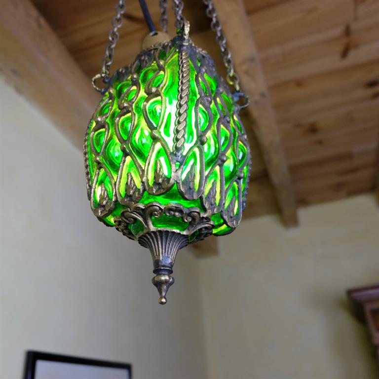La lampe Anzû est une suspension décorative qui diffuse une jolie lumière verte