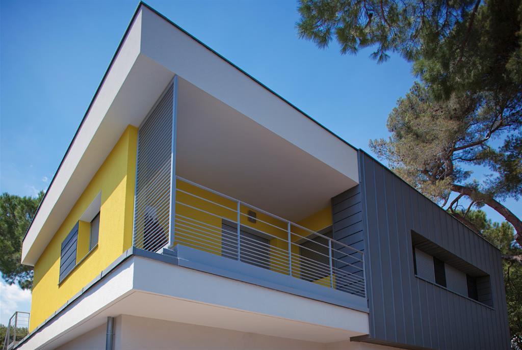 Villa avec façade jaune et partie en zinc  