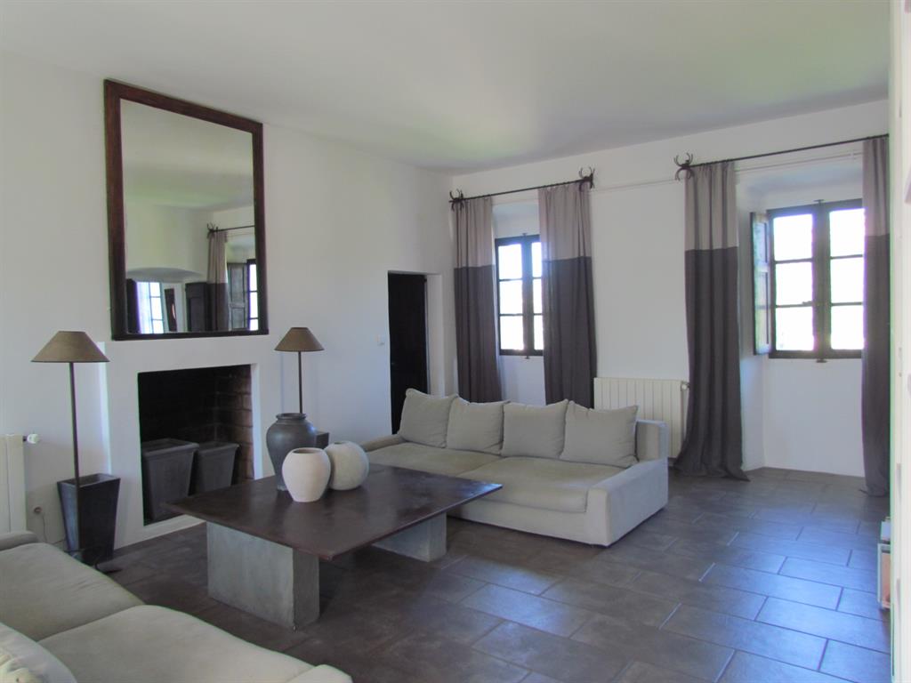 Salon moderne aux couleurs taupe, lins, marron, blanc. Carrelage brun. Rideaux bicolores. 