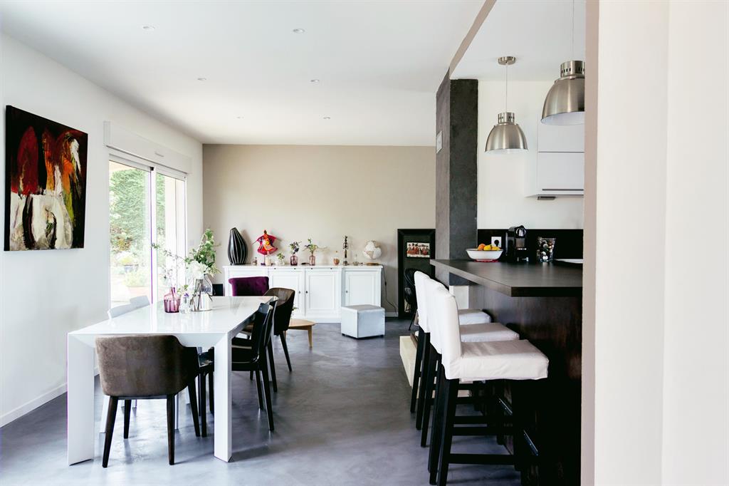 Pièce à vivre avec cuisine ouverte et grande table blanche