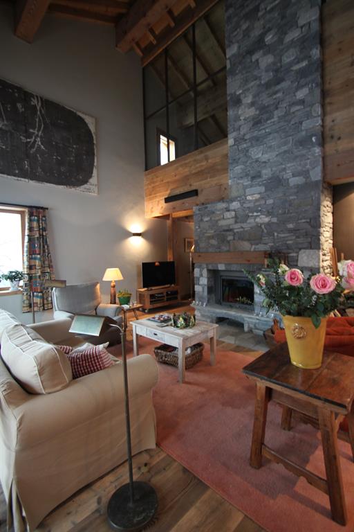Salon de chalet de montagne chaleureux avec cheminée en pierres