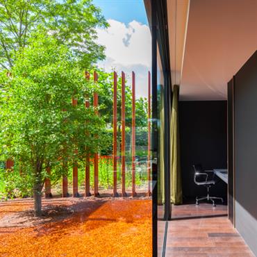 Les lames en acier Corten agissent comme une protection, apportant de l'intimité à la maison et la protégeant du soleil 