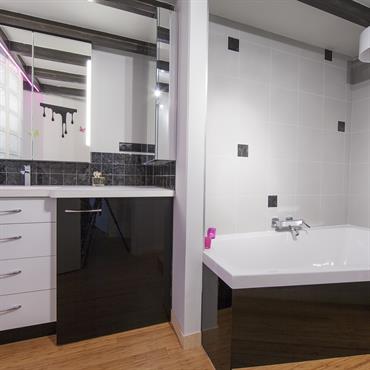 Salle de bains moderne noir et blanc, plan vasque et meuble sur mesures, paroi en pavés de verre. 
