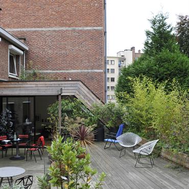 Grande terrasse bois et végétaux dans un environnement urbain