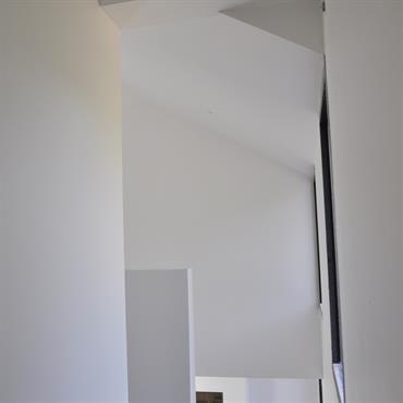 Perméabilité du regard, mise en perspective des espaces. Depuis le couloir des chambres enfant, une vision dérobée du séjour. 