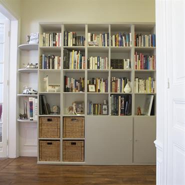 Bibliothèque grise avec rangements en bas 