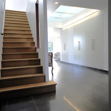 Dans cette montée d'escalier contemporaine, la douceur du bois des marches d'escalier s'associe avec la fraicheur des tons noir et blanc .  