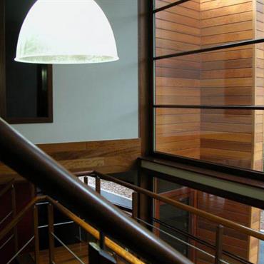 Détail de la baie vitrée depuis l'escalier. Transparence, naturel et noblesse des matériaux font de cette habitation contemporaine un modèle d'architecture. 