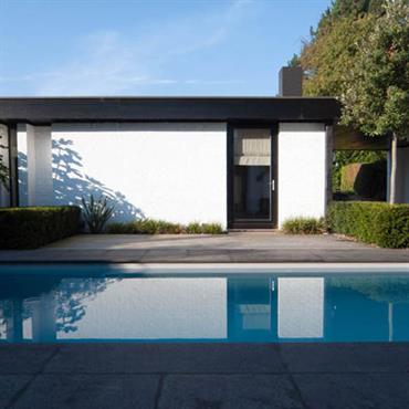 Maison de plain pied avec patio donnant sur une piscine rectangulaire