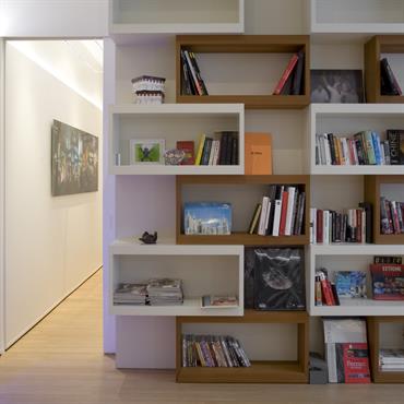 Bibliothèque sur mesure avec volumes géométriques blancs et bois. 