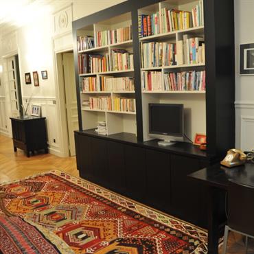 Bibliothèque contemporaine noire dans un appartement à moulures. réalisée sur mesure 