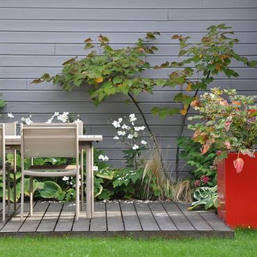 Petit jardin avec terrasse en bois aménagée d'une salle à manger d'extérieur