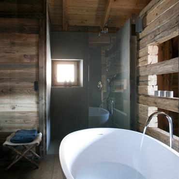 Entre rusticité et design, la salle de bain apporte le luxe des équipements dernière génération comme cette grande baignoire îlot.  