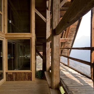 Terrasse extérieure aménagée à l'intérieur du volume de la charpente