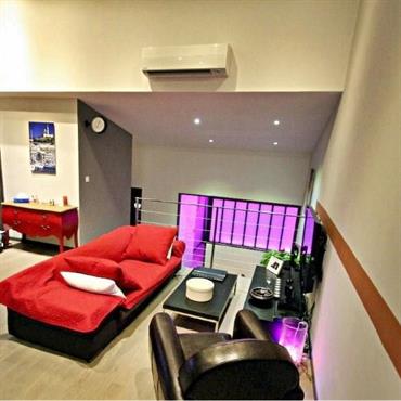 Salon contemporain en double-hauteur ouvert sur la chambre. Rouge et rose dynamisant l'espace. 