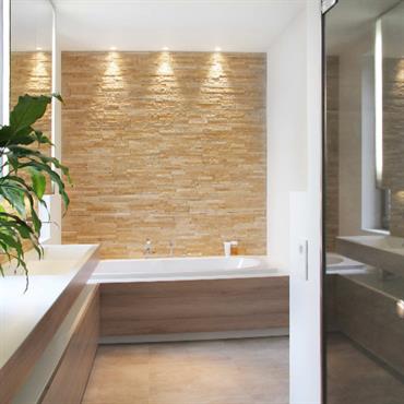 Salle de bain moderne avec mur du fond recouvert de briquettes