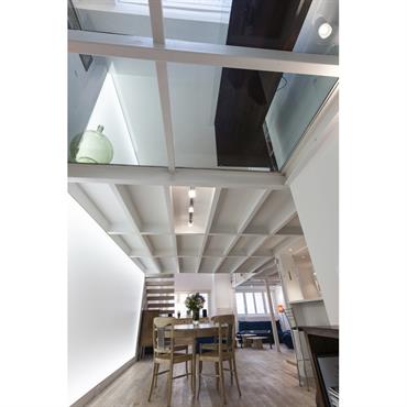 Mezzanine opaque et transparente du loft. Le plancher de verre agrandit l'espace et laisse passer la lumière zénithale. 