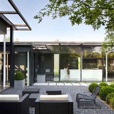 Terrasse en gravier pour une maison avec des façades en verre