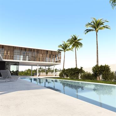 Terrasse ombragée en béton face à la piscine 