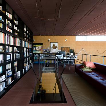 Le système Ya Ya Oh d'Ingo Maurer éclaire la trémie de l'escalier d'acier brut. Le bureau de la série Nomos, dessinée par Norman Foster pour Tecno, est complété par la ...