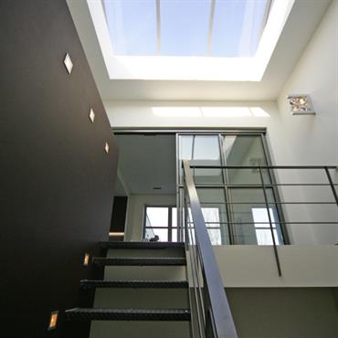 Escalier ajouré en lumière zénithale. Marches en acier avec relief antidérapant 