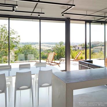 Plan de travail en béton pour la cuisine, salle à manger avec vue sur le paysage. 