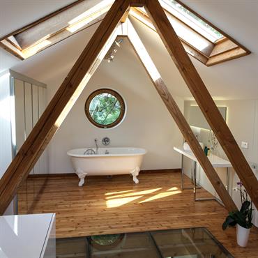 La chambre est accessible par un escalier. Le meuble sert de rangement et de garde corps. La charpente sépare la partie chambre de la partie sale de bain et encadre ...