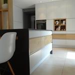Cuisine contemporaine blanche avec ilot et table en bois