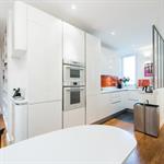 Une verrière sépare l'entrée de la cuisine