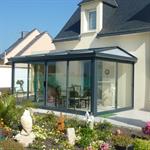 Véranda classique avec un toit en polycarbonate et baies vitées