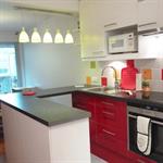 Cuisine avec meubles du bas rouges et ceux du haut blancs