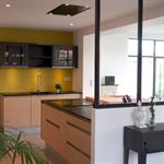 Les menuiseries métalliques noires créent une séparation physique tout en laissant