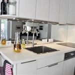 Petite cuisine blanche moderne avec miroir en guise de crédence