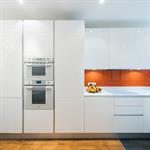 Meubles blancs laqués et crédence en verre orange