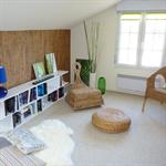 Espace lecture avec une bibliothèque et des fauteuils