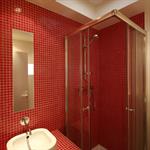 Salle d'eau en mosaïque rouge et puit de lumière