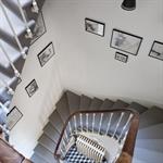 Cage d'escalier carrée aménagée de cadres photos